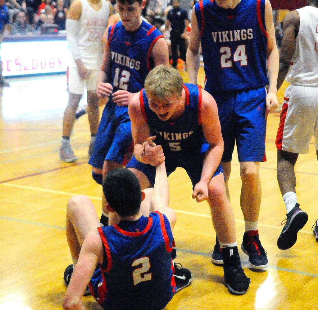Willapa Valleys Peter Hamilton (5) celebrates with Logan Walker (2) after Walker hit a contested layup late in the fourth quarter against Ilwaco on Friday. (Hasani Grayson | Grays Harbor News Group)
