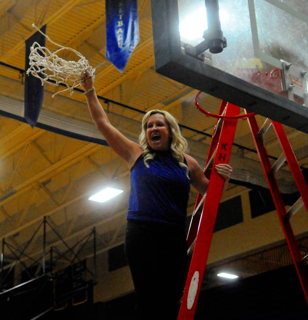 Elma head coach Lisa Johnson cuts down the net after the Eagles defeated Kings Way Christian 48-37 to win the IV District title. (Hasani Grayson | Grays Harbor News Group)