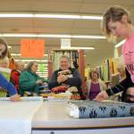 (Michael Lang | Grays Harbor News Group) Chelsie Vogel, left, and Karen Martin cut fabric for the long line of customers last Friday at Elma Variety Store.