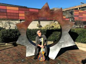 Louis Krauss | Grays Harbor News Group                                ARM Director Wil Russoul sits on a statue in downtown Aberdeen. Hes working to start a creative district in the city.