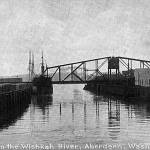 A photo from 110 years ago, when the Northern Pacific railroad bridge across the Wishkah River was new. This photo was taken looking south from the second Heron Street Bridge which opened in 1905. On the east side of the Wishkah River is the S.E. Slade Lumber Mill (present-day site of the Best Western Motel). The building with the peaked roof visible on the extreme right was the office of the Sailors Union of the Pacific with the notorious Billy Gohl serving as the local agent at the time of this photo. (Roy Vataja Collection)