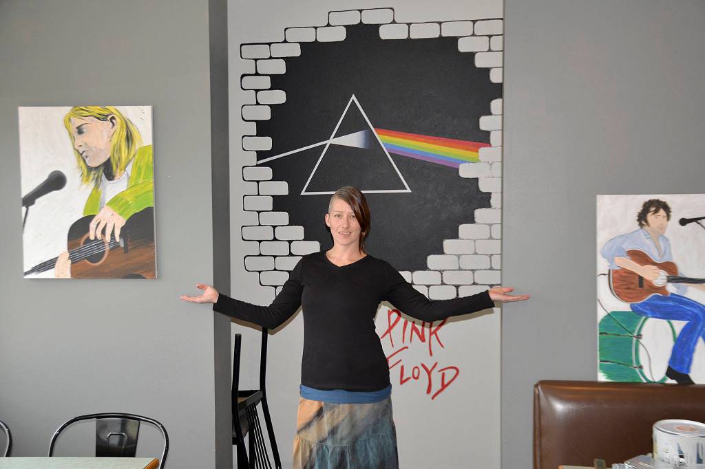 DAN HAMMOCK | GRAYS HARBOR NEWS GROUP Local artist Nina Yates with some of her works on display at the RocknBrews restaurant in Westport, due to open April 1. Behind her is a mural that combines the unmistakable art from Pink Floyds The Wall and Dark Side of the Moon albums. The canvases feature artists with local roots, Kurt Cobain of Nirvana and Leroy Virgil of Hellbound Glory.