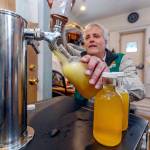 Weavers Way Co-op store manager Rick Spalek fills 16-ounce bottles with GTS Cannabliss kombucha, which contains CBD. (Michael Bryant | The Philadelphia Inquirer)