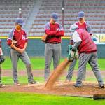 Hoquiam players look on as assistant coach Zac Reynvaan dumps Turface on the mound between innings after heavy rain in the early innings. (Hasani Grayson | Grays Harbor News Group)