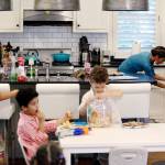 Emily Haney | Atlanta Journal-Constitution                                 Debra Shigley heats up food for her youngest child while the four other enjoy a snack and a movie at home. Shigley has employed several hacks to keep life running smoothly , but mostly she tries to stay in the moment.
