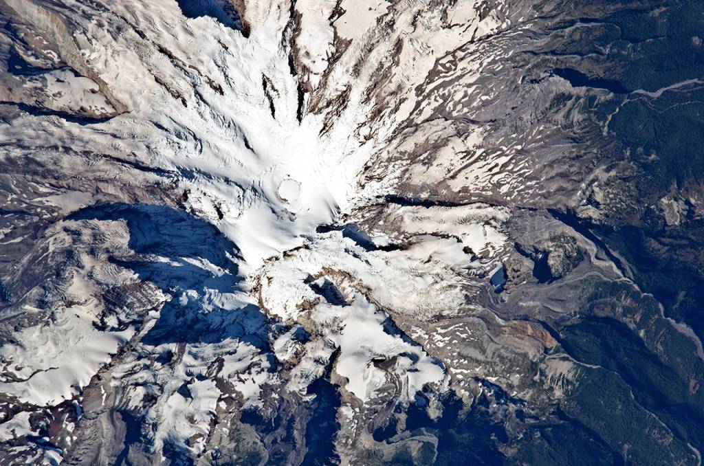 (NASA) With the ending of the last Ice Age, as the continental and alpine glaciers melted, the ocean levels rose to our current sea level. Pictured are the glaciers remaining on Mt. Rainier.