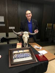 Ex-Aberdeen Police Chief Bob Torgerson poses with some of the gifts he received during a retirement reception, including a steers skull signed by everyone in his department.