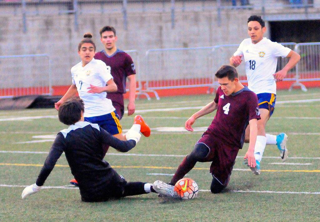 Montesanos Veli Ambrocio (4) is met by Forks keeper Gabriel Terrones in the box on a one-on-one opportunity in the second half on Wednesday. (Hasani Grayson | Grays Harbor News Group)