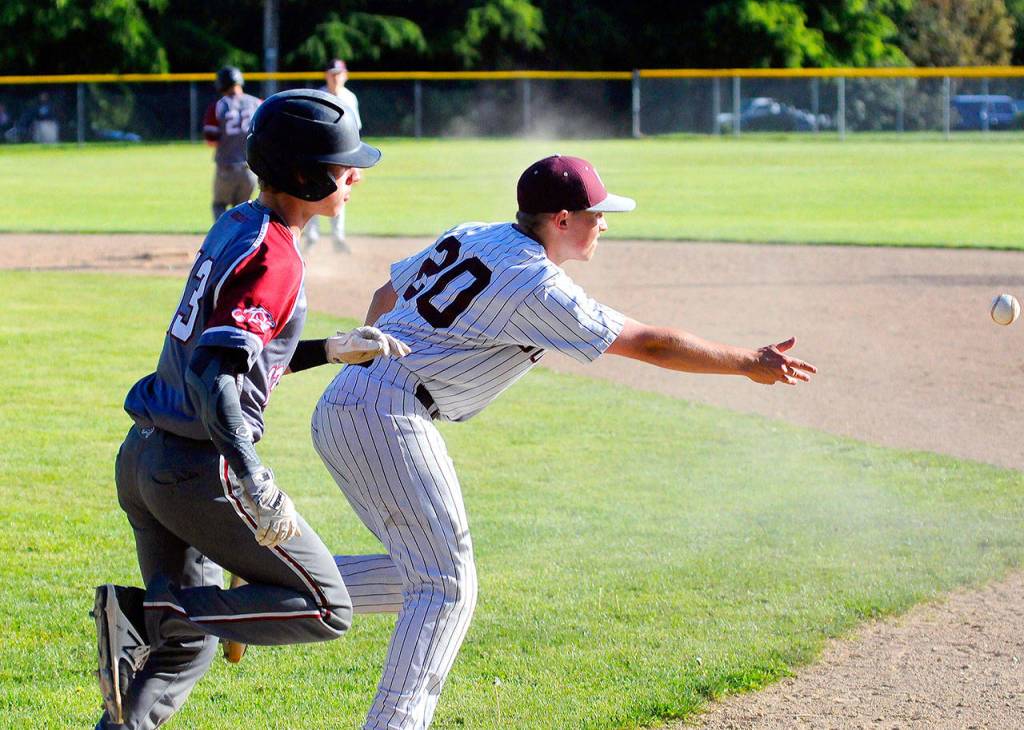 Montesanos Payson Parker tosses the ball to first to put out Hoquiams Troy McMinn on Friday. (Hasani Grayson | Grays Harbor News Group)