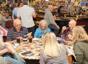 (Courtesy photo) Grant Edwards, right, takes a bite of his 100th birthday cake Saturday during a celebration at the Veterans of Foreign Wars hall in Montesano.