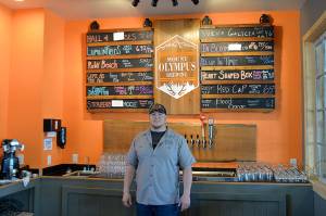 photos by Louis Krauss | Grays Harbor News Group                                Brewer Orlando Maldonado stands in front of the current beer list at Mount Olympus Brewing Company in Aberdeen.