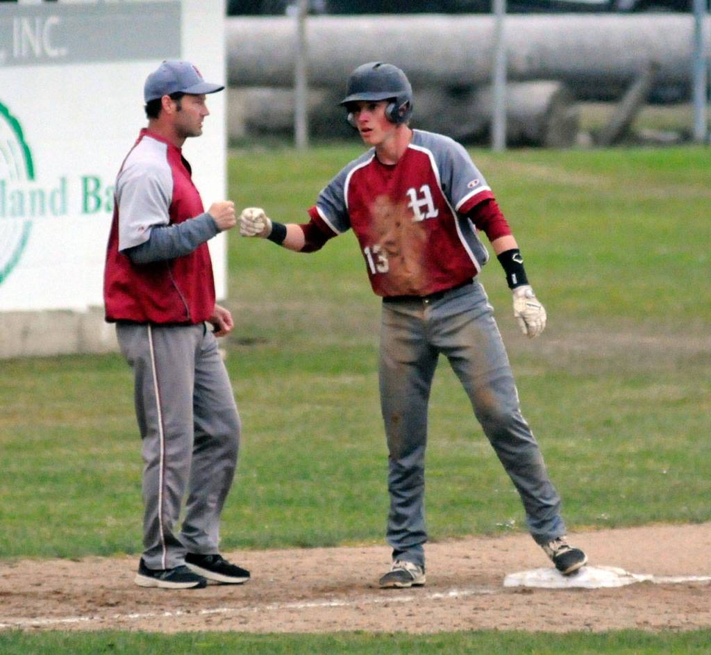 Hoquiams Troy McMinn, right, gets a fist bump from head coach Steve Jump after McMinn hit a triple in the fourth inning of Saturdays district title game against the Montesano Bulldogs. (Ryan Sparks | Grays Harbor News Group)