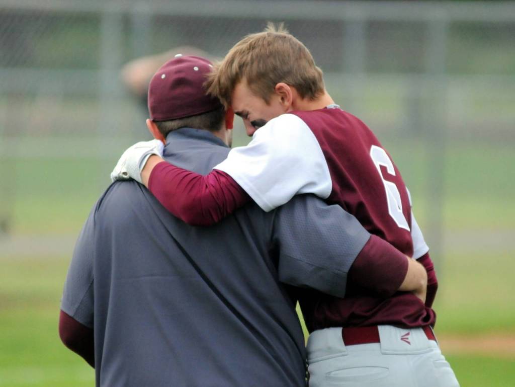 Montesanos Cole Daniels is consoled after the final out of the Bulldogs 4-3 loss to Seattle Christian in a 1A regional final at Castle Rock High School. (Ryan Sparks | Grays Harbor News Group)