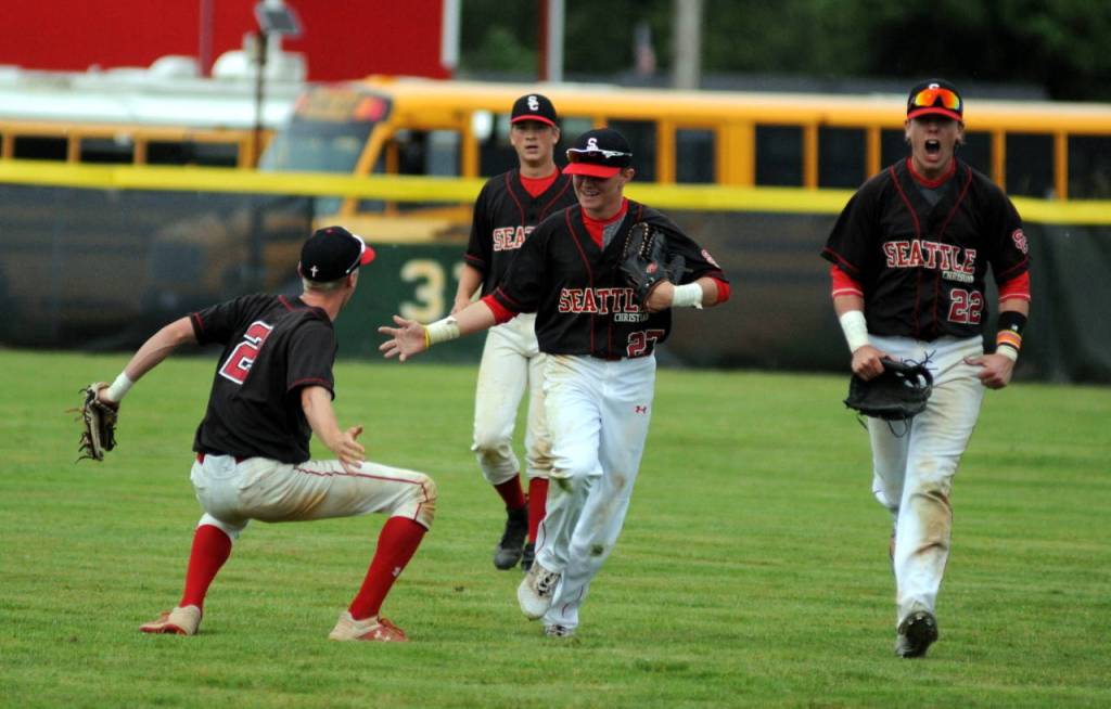 Seattle Christian players celebrate after centerfielder Jeffrey Sichmeller, middle, robbed Montesanos Teegan Zillyett of the potential game-tying hit in the sixth inning of a 1A regional final on Saturday in Castle Rock. (Ryan Sparks | Grays Harbor News Group)