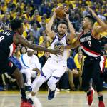 Stephen Curry of the Golden State Warriors drives to the basket against Al-Farouq Aminu (8) and CJ McCollum (3) of the Portland Trail Blazers during the first half in game one of the NBA Western Conference Finals at ORACLE Arena on May 14. (Ezra Shaw | Getty Images)