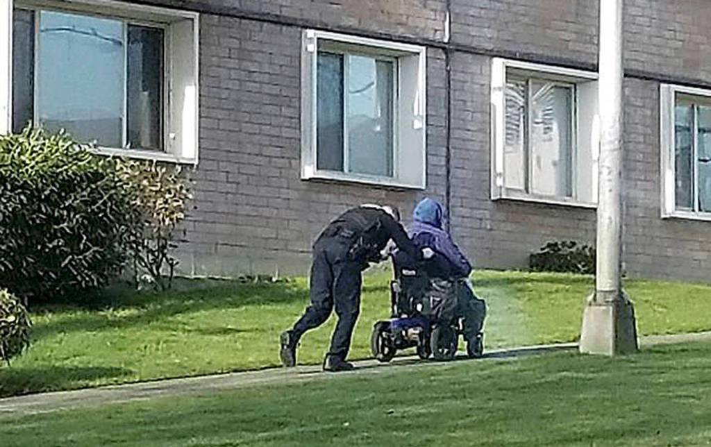 COURTESY PHOTO                                Aberdeen Police Sgt. Darrin King noticed a man in a wheelchair struggling to get up Broadway last July. He got out and pushed the chair up the hill to level ground. Officer Brandi Zieber took the photo.