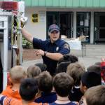 Hoquiam Fire Department firefighter shows off the features of a fire engine to Emerson Elementary School students on Vehicle Day on June 13. (Hasani Grayson | Grays Harbor News Group)