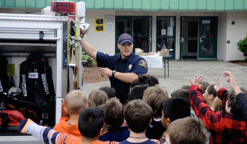 Hoquiam Fire Department firefighter shows off the features of a fire engine to Emerson Elementary School students on Vehicle Day on June 13. (Hasani Grayson | Grays Harbor News Group)
