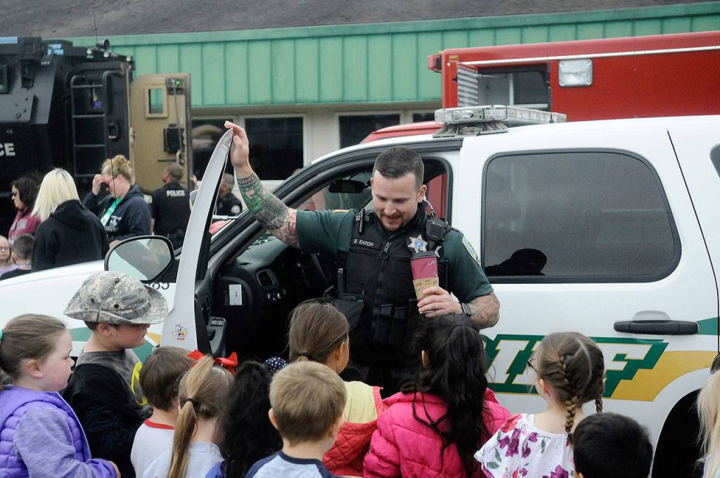 Grays Harbor County sheriff deputy Benjamin Eaton shows talks to Emerson Elementary school students in front of his law enforcement Vehicle Day on June 13. (Hasani Grayson | Grays Harbor News Group)