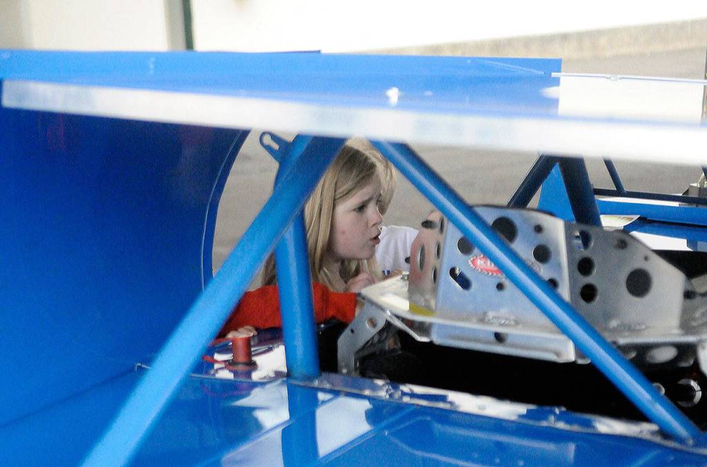 Emerson Elementary School student Taylor Sweers peers into Zack Simpsons race car on Vehicle Day on June 13. (Hasani Grayson | Grays Harbor News Group)