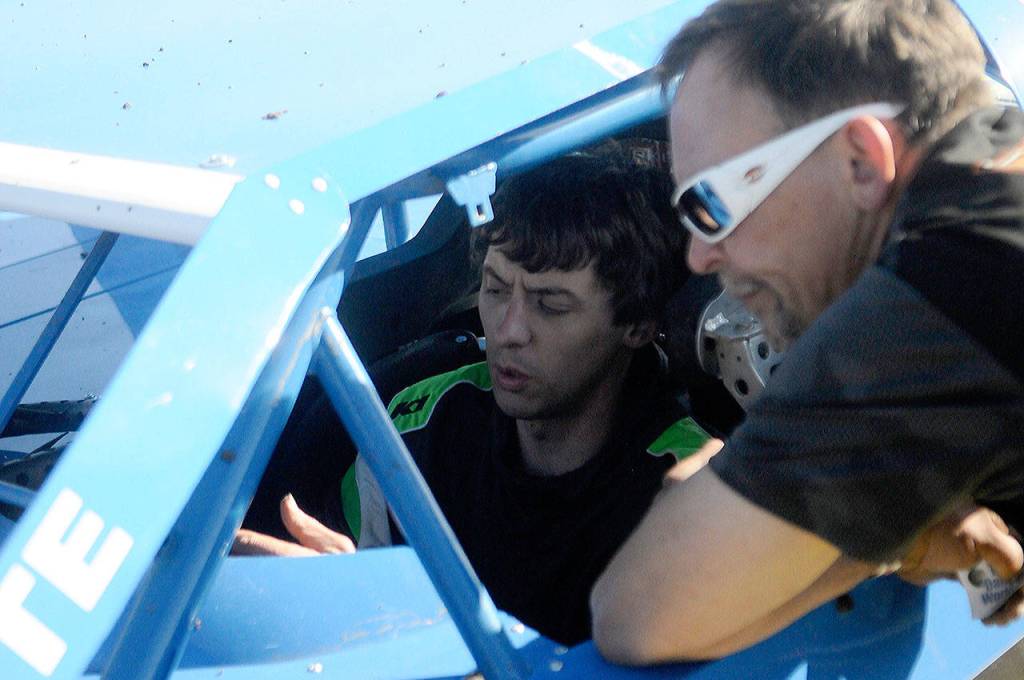 Driver Zack Simpson, left, and crew chief Pat Lamb discuss what changes need to made to Simpsons modified race car after the first heat race of the day at Grays Harbor Raceway on June 15. (Hasani Grayson | Grays Harbor News Group)