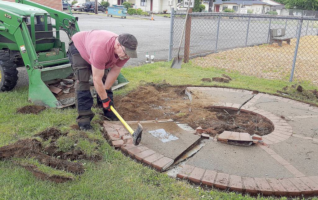 COURTESY MICHELLE AMES                                The existing Lindsey Baum memorial and its faded plaque were removed to make way for the new Lindsey Baum memorial garden at Beerbower Park in McCleary, which will be dedicated June 26. Arlee Rothwell, one of the many volunteers who worked on the garden, uses a sledgehammer to break up the old memorial.