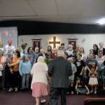 Delma Gilroy, left and John Gilroy, right, walk towards the front of the chapel to take a family photo with all their blood relatives in attendance at the couples 70-year anniversary Lake Quinault Valley Chapel on Saturday. (Hasani Grayson | Grays Harbor News Group)