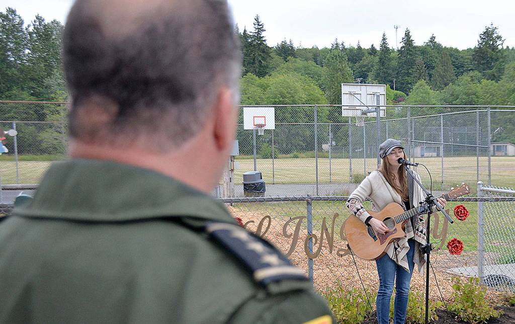 DAN HAMMOCK | GRAYS HARBOR NEWS GROUP                                Grays Harbor County Sheriff Rick Scott watches local singer/songwriter Ericka Corban perform I Will See You Again at the Lindsey Baum remembrance garden dedication in McCleary Wednesday.