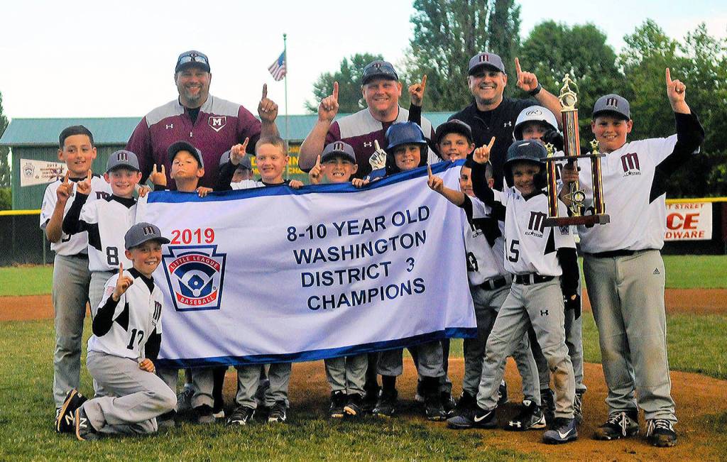 Montesanos 8-10 year-old team holds up its district title banner and trophy after beating Centralia on Friday in Chehalis. (Hasani Grayson | Grays Harbor News Group)