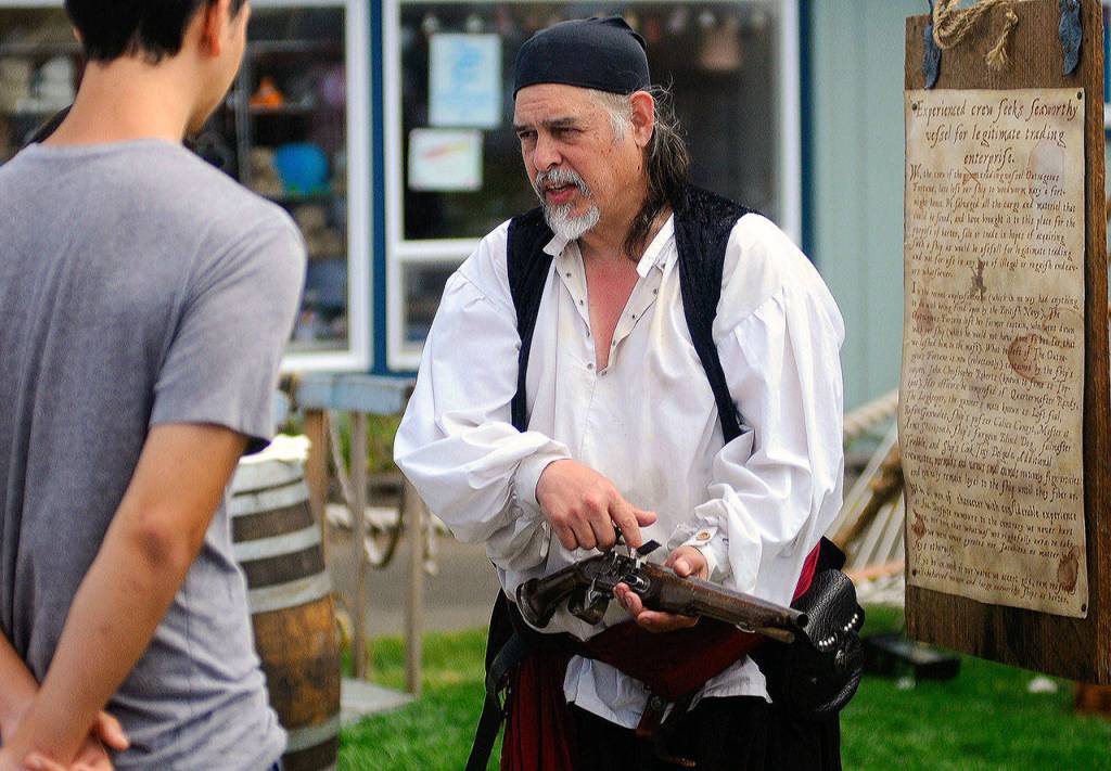 Outrageous Fortune pirate reenactor Alan Jubin AKA Calicoe Cuneuit shows the workings of an old pistol during Pirate Daze at the Marina in Westport on Saturday. (Hasani Grayson | Grays Harbor News Group)