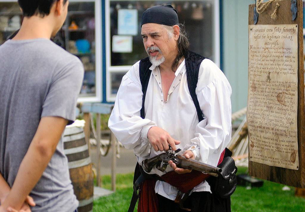 Hasani Grayson | Grays Harbor News Group Outrageous Fortune pirate reenactor Alan Jubin AKA Calicoe Cuneuit shows the workings of an old pistol during Pirate Daze at the Marina in Westport on Saturday.
