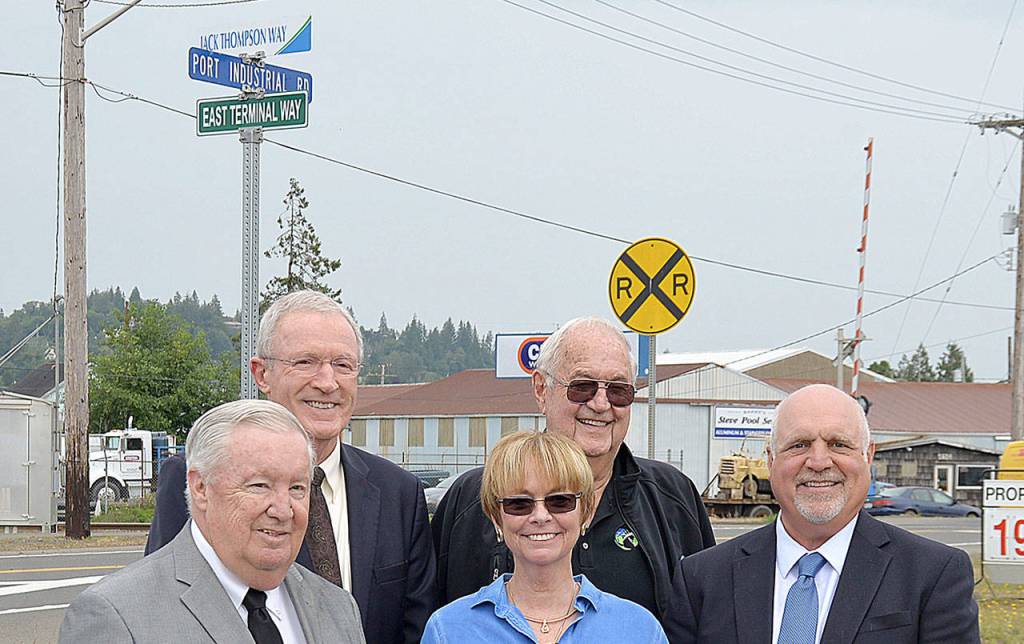 DAN HAMMOCK | GRAYS HARBOR NEWS GROUP                                From left, Port of Grays Harbor Commission President Stan Pinnick, Port Commissioner Tom Quigg, Trish Thompson, former commissioner Chuck Caldwell, and Port Commissioner Phil Papac stand beneath the sign designating East Terminal Way as Jack Thompson Way.