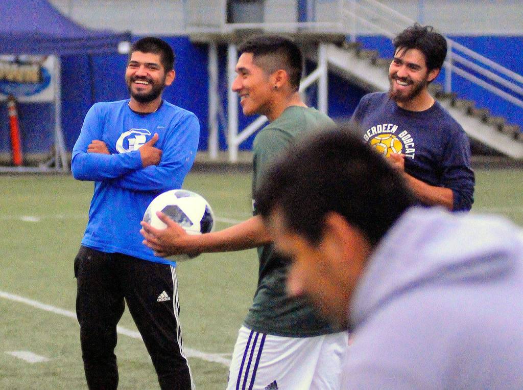 Cesar Carona, left, and Victor Carona, right, joke with Jaunito Lopez during a drill at practice. (Hasani Grayson | Grays Harbor News Group)