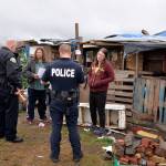 Louis Krauss | Grays Harbor News Group                                Aberdeen Police officers give homeless people along the Chehalis River 72-hour notices of needing to vacate.