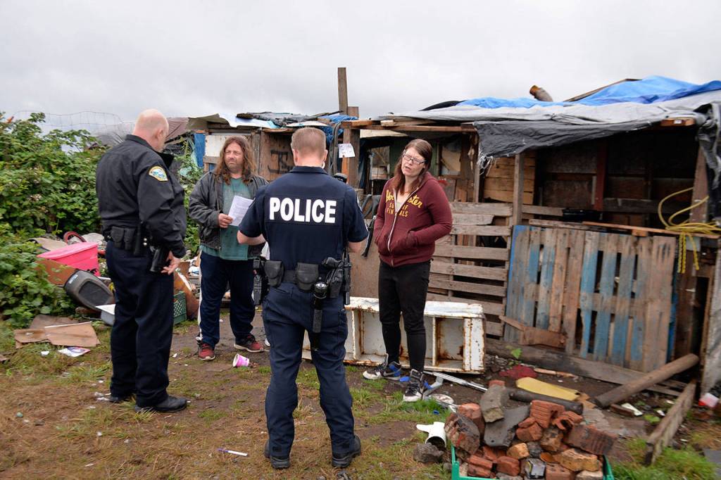 Louis Krauss | Grays Harbor News Group                                Aberdeen Police officers give homeless people along the Chehalis River 72-hour notices of needing to vacate.