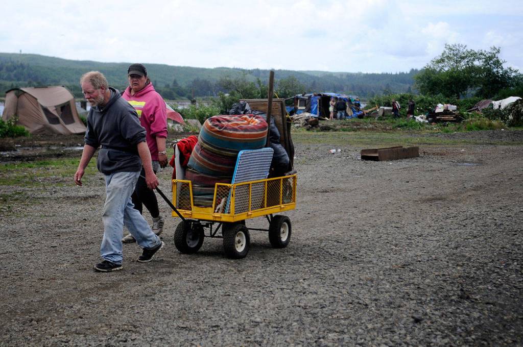 James Horack, 54, pulls a cart filled with personal belongings toward the Aberdeen City Hall parking lot shelter with Mary Oxley, 48.