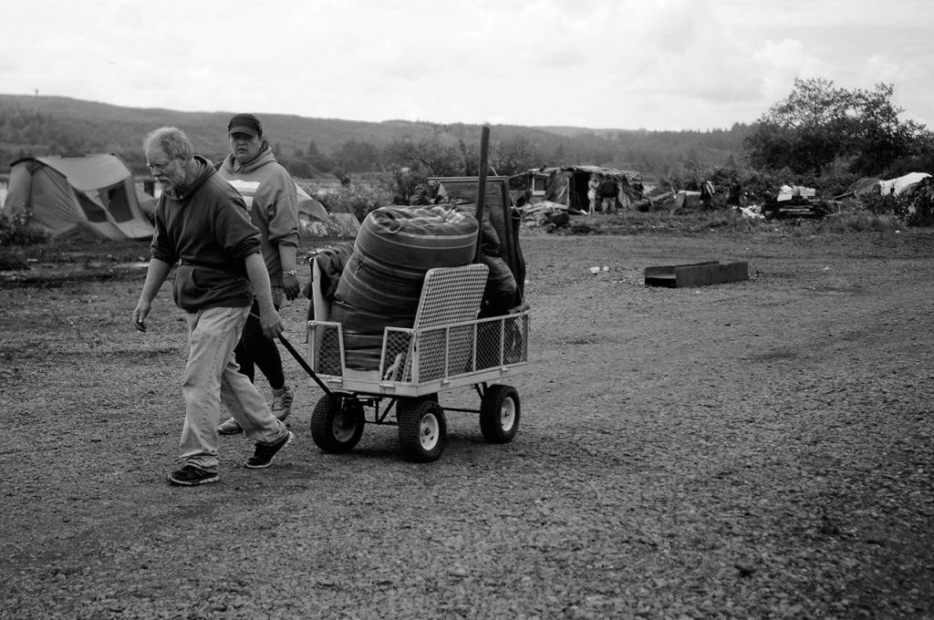 James Horack, 54, pulls a cart filled with personal belongings toward the Aberdeen City Hall parking lot shelter with Mary Oxley, 48.
