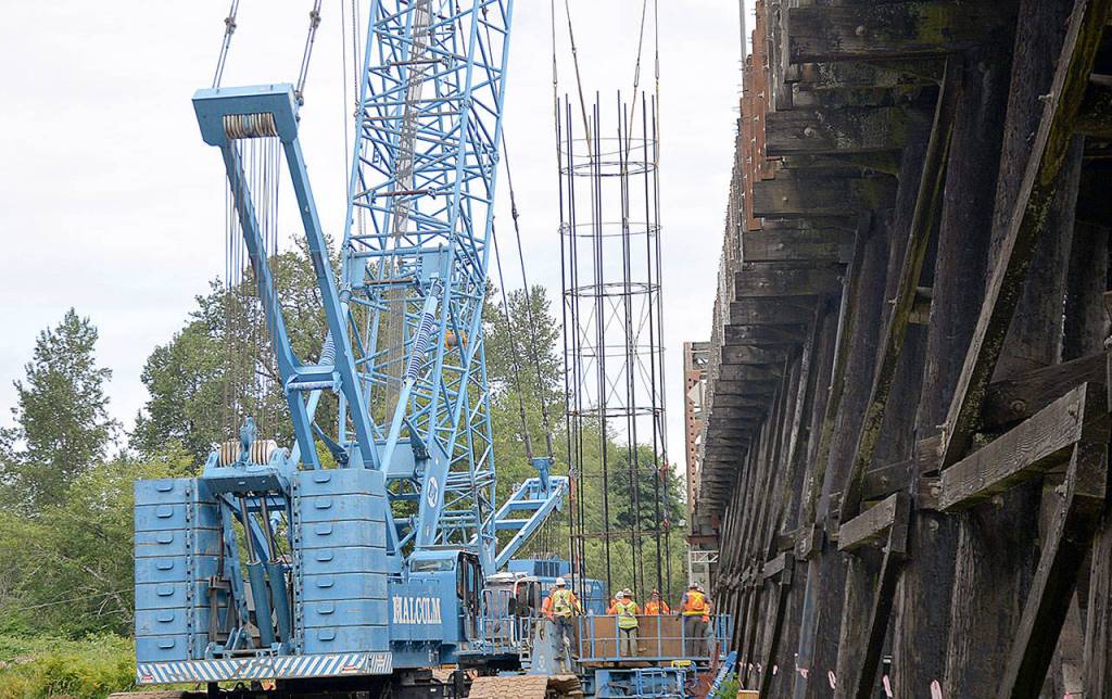 DAN HAMMOCK | GRAYS HARBOR NEWS GROUP                                A rebar cage is lowered into one of eight 10-foot diameter steel shafts on the west side of the State Route 107 bridge south of Montesano.