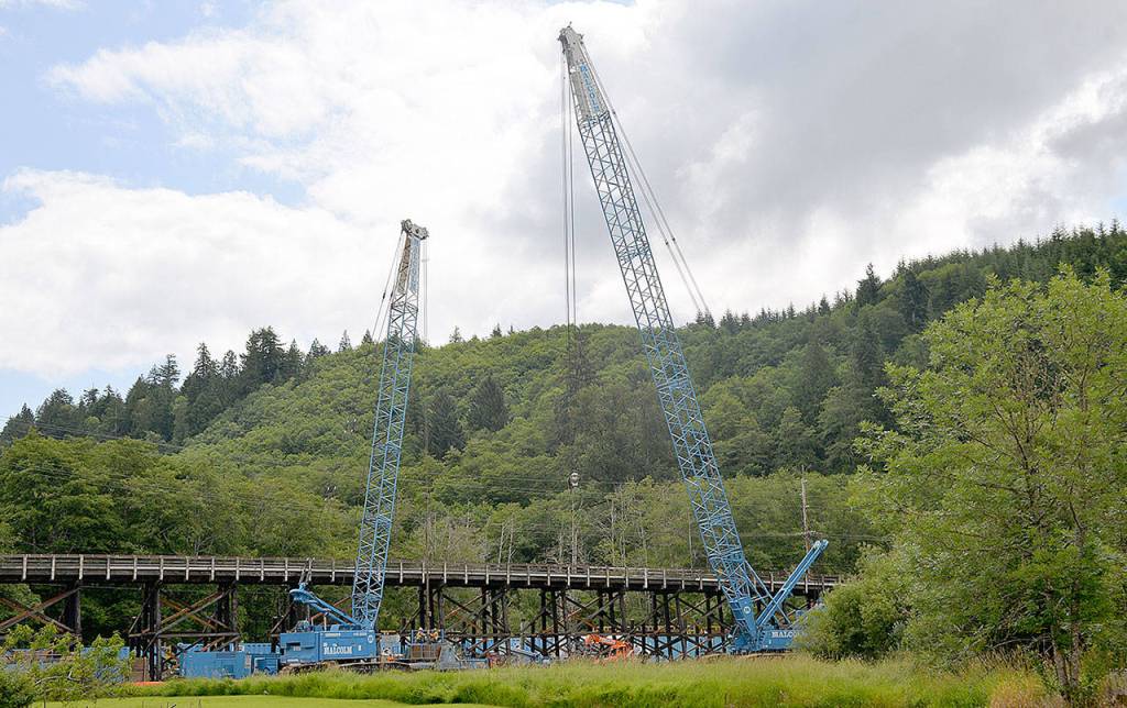 DAN HAMMOCK | GRAYS HARBOR NEWS GROUP                                Two cranes work the west side of the State Route 107 Chehalis River bridge south of Montesano. A crew from Rognlins Inc. was awarded the contract for the $23 million-plus project to replace the south approach and other upgrades to the bridge.