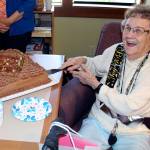 Photos by Dee Anne Shaw                                Ruth McCausland cuts the cake during her 100th birthday celebration in Olympia.