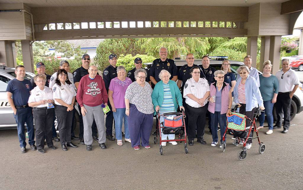 DAN HAMMOCK | GRAYS HARBOR NEWS GROUP                                First stop for the Hoquiam police and fire departments was Channel Point Village during Tuesdays National Night Out celebration. Here firefighters, police and city officials pose for a picture with a few of the retirement communitys residents.