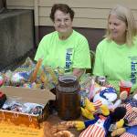 DAN HAMMOCK | GRAYS HARBOR NEWS GROUP                                Pat Muhlhauser, left, and Laura Foshaug work a table full of toys at the Hoquiam National Night Out event at the Hoquiam Elks Lodge Tuesday. Duck feathers were hidden around the grounds, and kids who found one could exchange it for a prize.