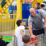 Carnival worker Albert Horton welcomes children onto the ferris wheel at the Grays Harbor County Fair on Friday. (Hasani Grayson | Grays Harbor News Group)