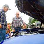 Junior Parris, left, and Tim Stangeland check out the engine of Parris El Camino at the Grays Harbor County Fair on Friday. (Hasani Grayson | Grays Harbor News Group)