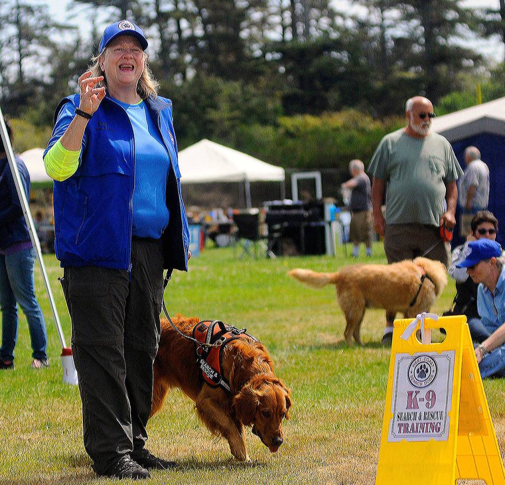 Hasani Grayson | Grays Harbor News Group                                Shay Jones of West Coast Search Dogs stands with rescue dog Duey as she explains how dogs can help find lost people at the Woof-a-Thon on Saturday.