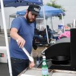 Aberdeen Mayor Erik Larson takes some food off the grill at Summerfest on Saturday. (Hasani Grayson | Grays Harbor News Group)