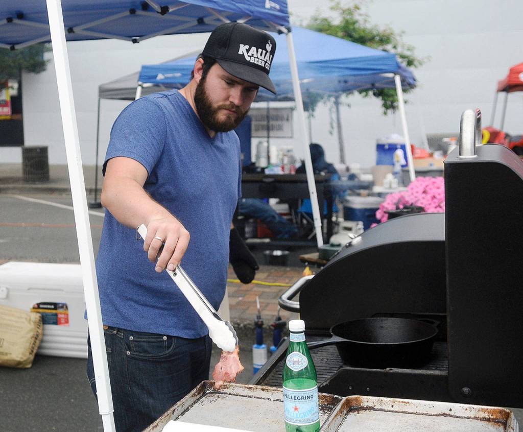 Aberdeen Mayor Erik Larson takes some food off the grill at Summerfest on Saturday. (Hasani Grayson | Grays Harbor News Group)