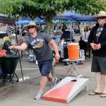 Michael Pickar, left, and Dan Ness play cornhole at Summerfest on Saturday. (Hasani Grayson | Grays Harbor News Group)