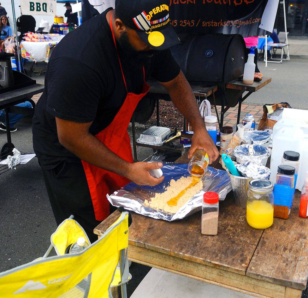 Mark Starks prepares food at Summerfest on Saturday. (Hasani Grayson | Grays Harbor News Group)