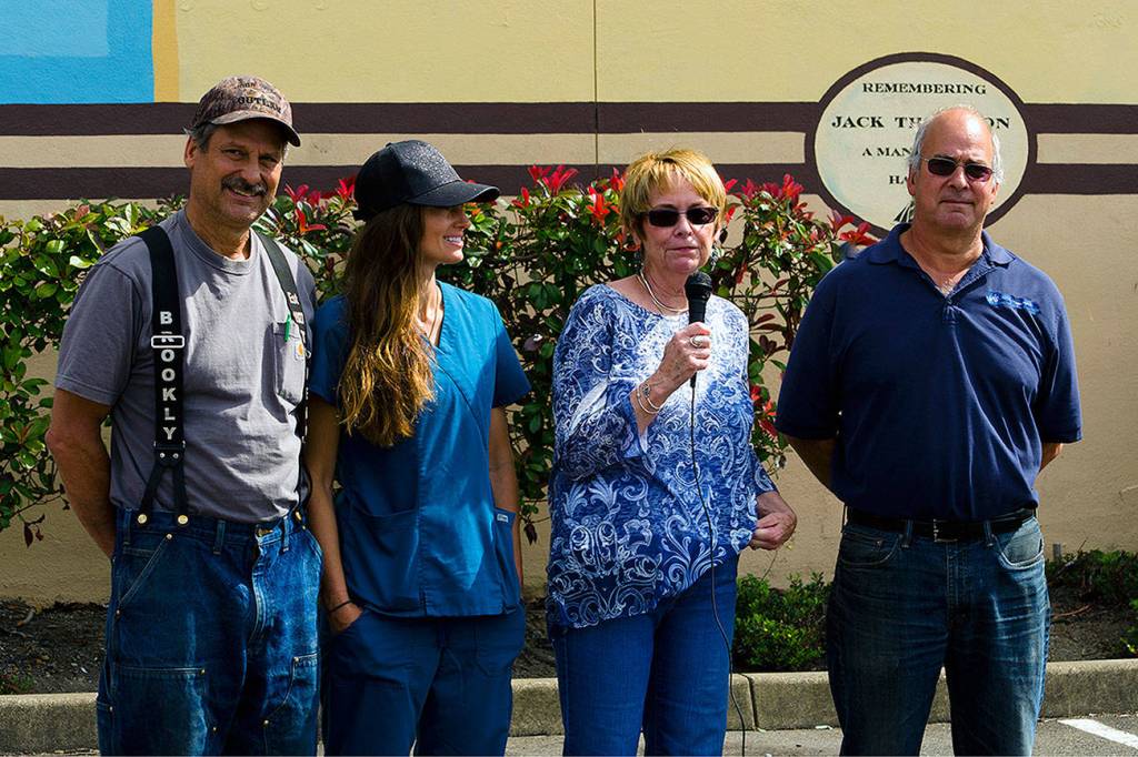 Jack Thompsons wife Trish (holding microphone) speaks at a dedication service for a new maritime mural, along with Jacks son Jack Jr., left, granddaughter Sunny Wheeler, and son Jerry Thompson. The mural was dedicated to Jack Thompson Sr., a former port commissioner who died this past October.